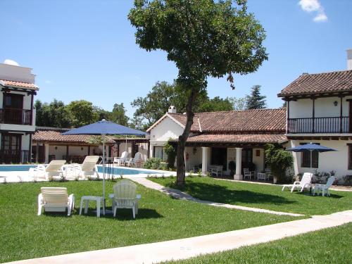 圣洛伦索Posada de los Poetas Hotel Boutique的一个带椅子的庭院、一个游泳池和一个房子