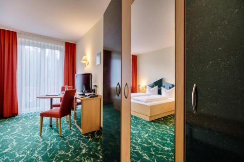 克林根塔尔沃格兰瓦尔德酒店的一间酒店客房,一间设有一张床和一张书桌