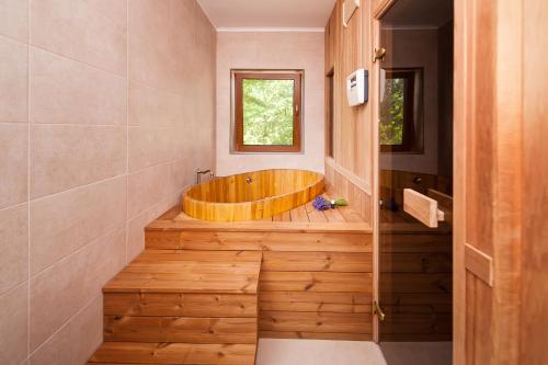 Valea TîrneiRose Hip Hill Guesthouse的带窗户的浴室内的木浴缸