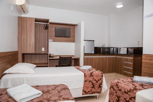 戈亚尼亚Hotel Belugi的酒店客房带两张床和厨房