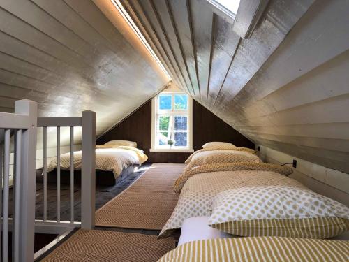 莱达尔绥里Den Gule Krambua - Gamle Lærdalsøyri - main street old town的阁楼卧室设有四张床和窗户。