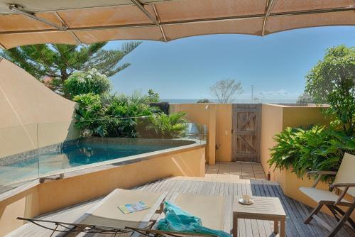 拜伦湾海滩套房酒店的一个带游泳池和遮阳伞的户外庭院