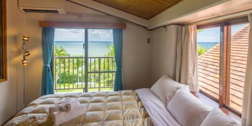 石垣岛石垣日落湾酒店的一间卧室配有一张床,享有海景