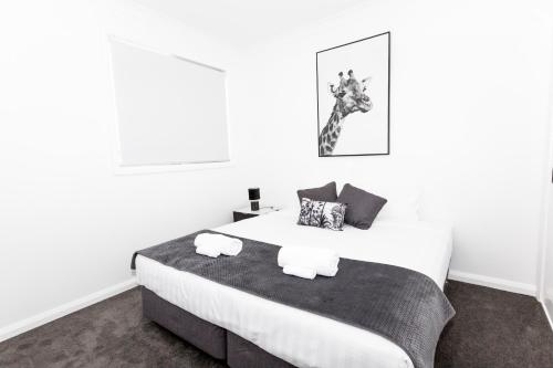 沃加沃加TWO TEN Sleeps 10! Luxury CBD Accommodation的一间卧室配有一张床,上面有两条毛巾