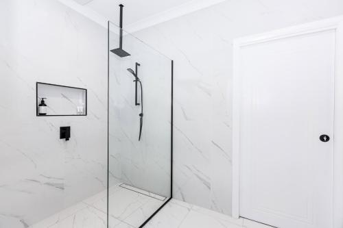 沃加沃加TWO TEN Sleeps 10! Luxury CBD Accommodation的带淋浴的白色浴室和玻璃门