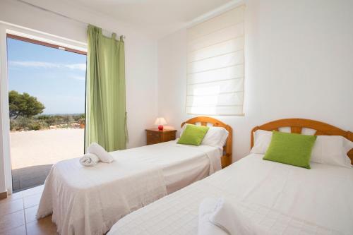 圣弗朗西斯科哈维尔VILLA Can Guillem d'es Puig的卧室设有两张床,享有海滩美景