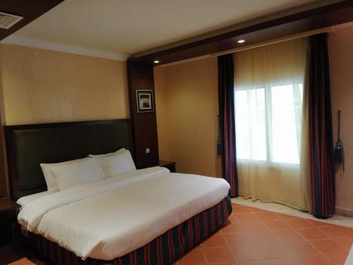 杜拉特阿拉尔Durrah Beach Apartment的一张位于酒店客房的大床,设有窗户