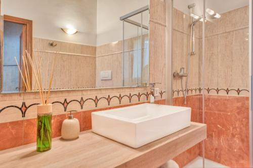莱切Corte Anibaldi Apartment的浴室设有白色水槽和镜子