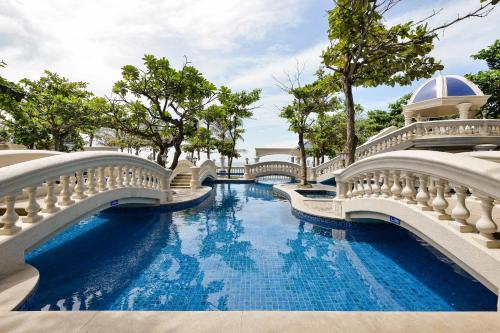隆海Lan Rung Resort Phuoc Hai的一座带桥梁和树木的游泳池