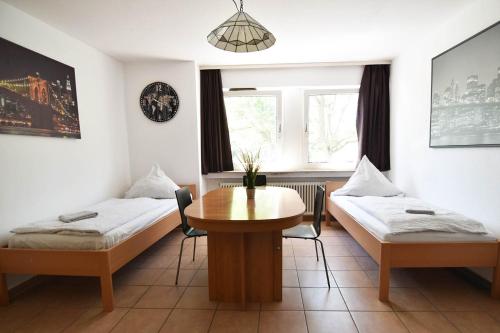 科隆Köln Höhenberg的客房设有两张床、一张桌子和一扇窗户。