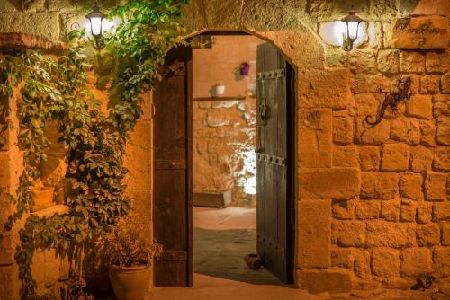 于尔居普卡帕多西亚套房酒店的石头建筑的入口,设有开放式门