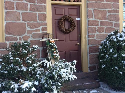 Reinholds布朗斯通殖民地风格住宿加早餐旅馆的紫色的门,上面有圣诞花圈