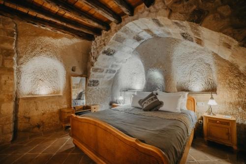 于尔居普卡帕多西亚套房酒店的石头间内一间卧室,配有一张床