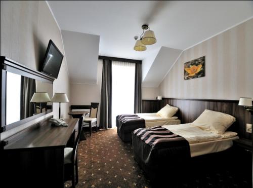 科宁HOTEL NIAGARA的酒店客房,设有两张床和一张沙发