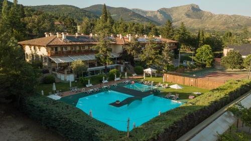 纳瓦塞拉达Hotel Rural Spa & Wellness Hacienda Los Robles的享有带游泳池的度假村的空中景致