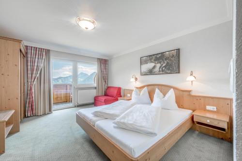 延巴赫Gasthof und Hotel Rieder GmbH的酒店客房,配有一张床和一张红色椅子
