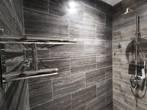 斗湖Foresight Hotel的浴室铺有木质瓷砖,设有淋浴。