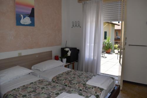 托尔博莱艾玛别墅旅馆的一间卧室设有两张床和滑动玻璃门