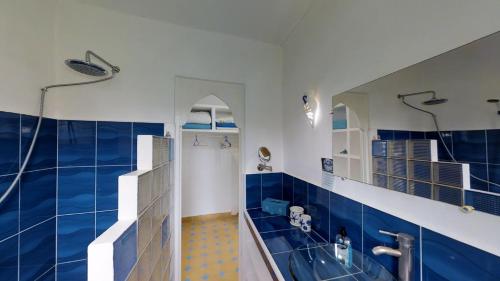 Ghazoua大巴别墅酒店的蓝色和白色的浴室设有淋浴和浴缸。