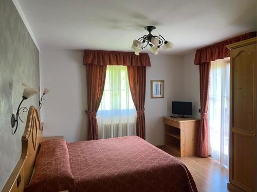 平佐洛高尔夫别墅的一间卧室配有床、电视和窗帘