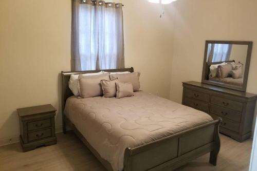 哈蒙德Villa 8的一间卧室配有一张带镜子和梳妆台的床