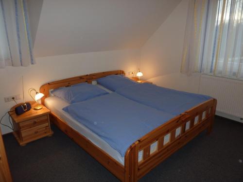 谢勒豪Ferienwohnung Cafe`Rotter , Brigitte und Jürgen Rotter的一间卧室配有一张大木床和蓝色床单