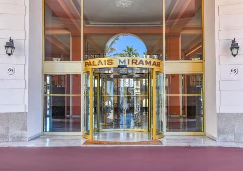 戛纳Palais Miramar Imperial Croisette的黄色旋转门的建筑物入口