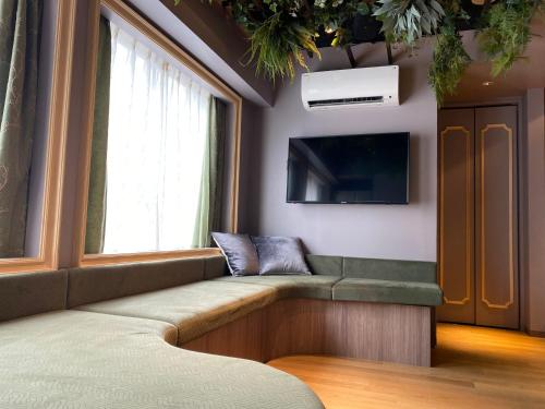 东京THE WARDROBE Hotel Shimokitazawa的一间带长凳和电视的等候室
