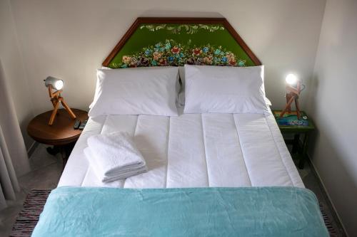 多明戈斯马丁斯Pousada Rua de Lazer的卧室内的一张床位,配有两张台灯