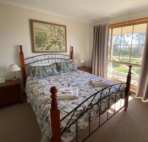 克莱尔Windmill Cottage的一间卧室设有一张床和一个大窗户