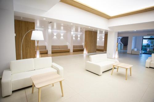 马马亚Zenith - Top Country Line - Conference & Spa Hotel的客厅配有2张白色沙发和1张桌子