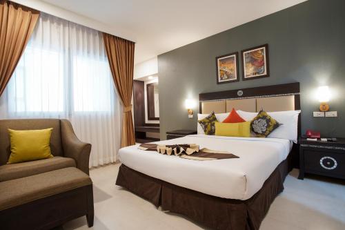 曼谷Club Mahindra Mac Boutique Hotel的酒店客房带一张大床和一把椅子