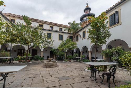 弗龙特拉堡拉阿尔莫雷玛酒店的一个带桌子和树木的庭院和一座建筑