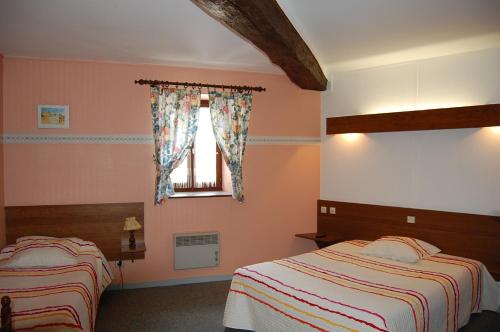 Champlitte-et-le-Prélot东荣酒店的一间卧室设有两张床和窗户。