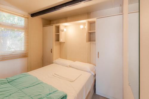 坎佩略邦索尔露营酒店的小房间设有两张床和一个衣柜