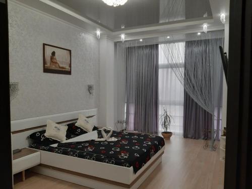 敖德萨Маршала Малиновського 18 б 12 Жемчужина квартира的一间卧室设有一张床和一个大窗户
