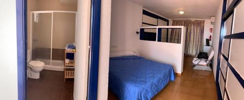 科尼尔-德拉弗龙特拉Hotel Playa Conil的一间带蓝色床的卧室和一间浴室