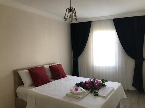 伊兹密尔Apart TU Çeşme的一间卧室,床上放着鲜花