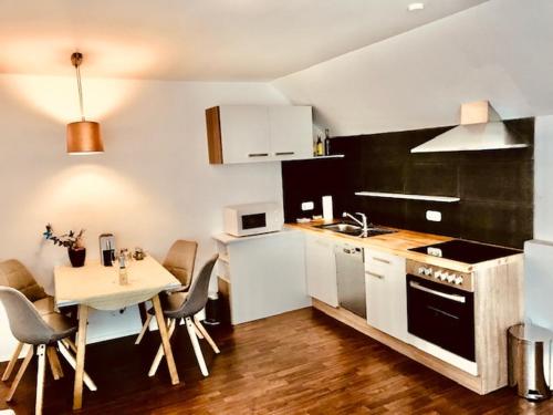 玛利亚采尔Mariazeller Resort Landliebe的一间带桌子的厨房和一间带白色橱柜的厨房