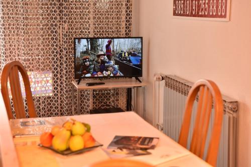 扎普雷希奇Apartman Jadranka的用餐室配有带水果的桌子和电视