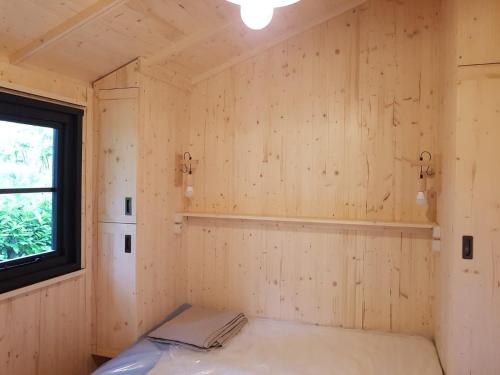 Moncrabeau乐穆利阿特露营地的一间设有木墙和窗户的客房
