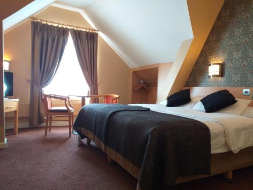 都柏林哈丁酒店的一间卧室配有一张床、一张书桌和一个窗户。