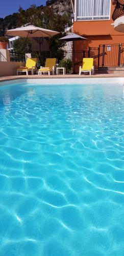滨海自由城弗罗尔酒店的一座带黄色椅子的大型游泳池和一座建筑
