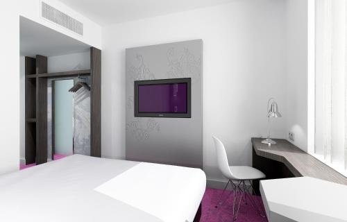 日内瓦VISIONAPARTMENTS Geneva Gare的卧室配有白色的床和墙上的电视
