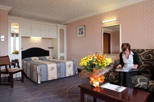 埃克斯茅斯德文寇特度假酒店的坐在酒店房间沙发上的女人