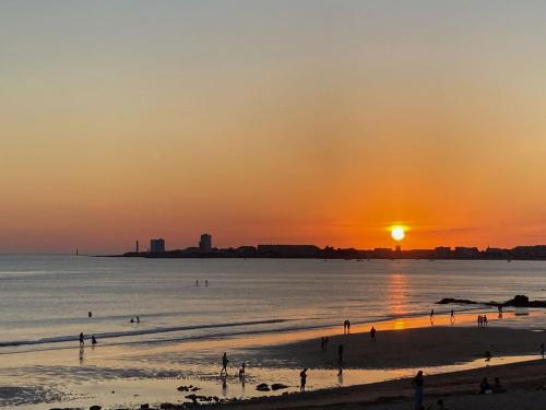 莱萨布勒-多洛讷Les portes du soleil的日落时分在海滩上一群人