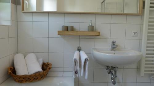 萨克森自由州诺伊斯塔滕FEWO am Markt的白色的浴室设有水槽和一篮毛巾