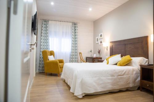 孔苏埃格拉Azafrán Consuegra的一间卧室配有一张大床和一张黄色椅子