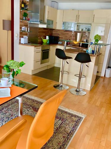 维也纳Luxurious city apartment incl garage and terrace的厨房配有两把椅子、一张桌子和一个柜台