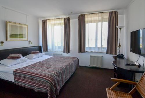 卡尼夫Knyazha Hora Hotel的配有一张床和一张书桌的酒店客房